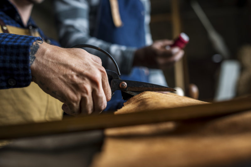 closeup craftsman cutting leather